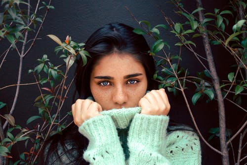 Woman in green sweater for Genetic influences on mental wellness post