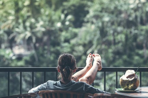 Woman is sitting on the porch enjoying The Benefits Of Nature Therapy