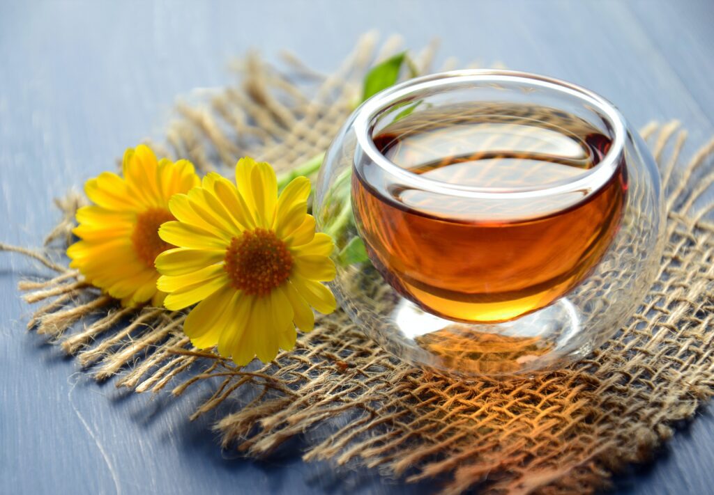 cup of Calming Chamomile Tea on a table near some flowers