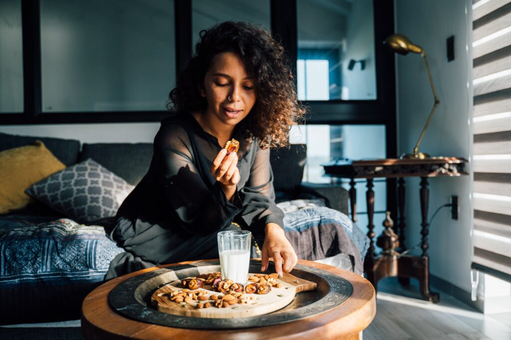 woman eating almonds and dates in Nutty Bliss Bites