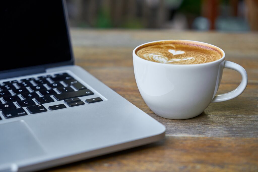 Cup of Golden Turmeric Latte sitting near a computer