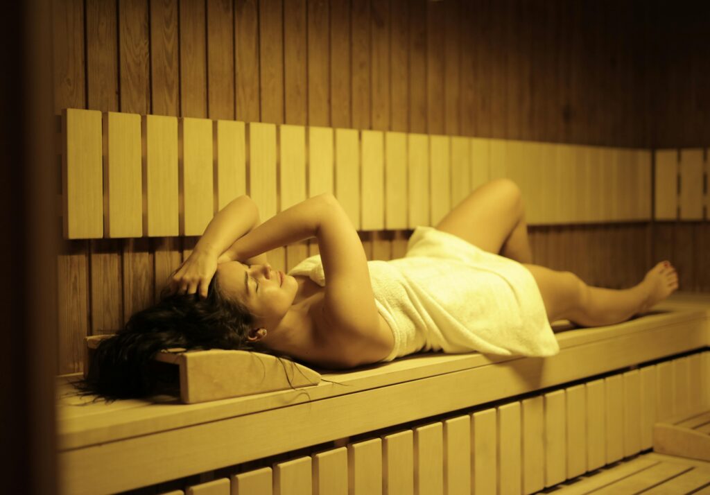 Woman laying in sauna in white towell