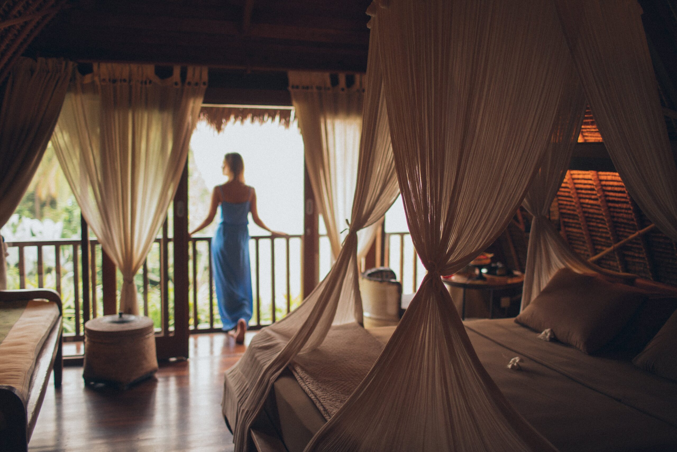 Woman standing near a window in first light