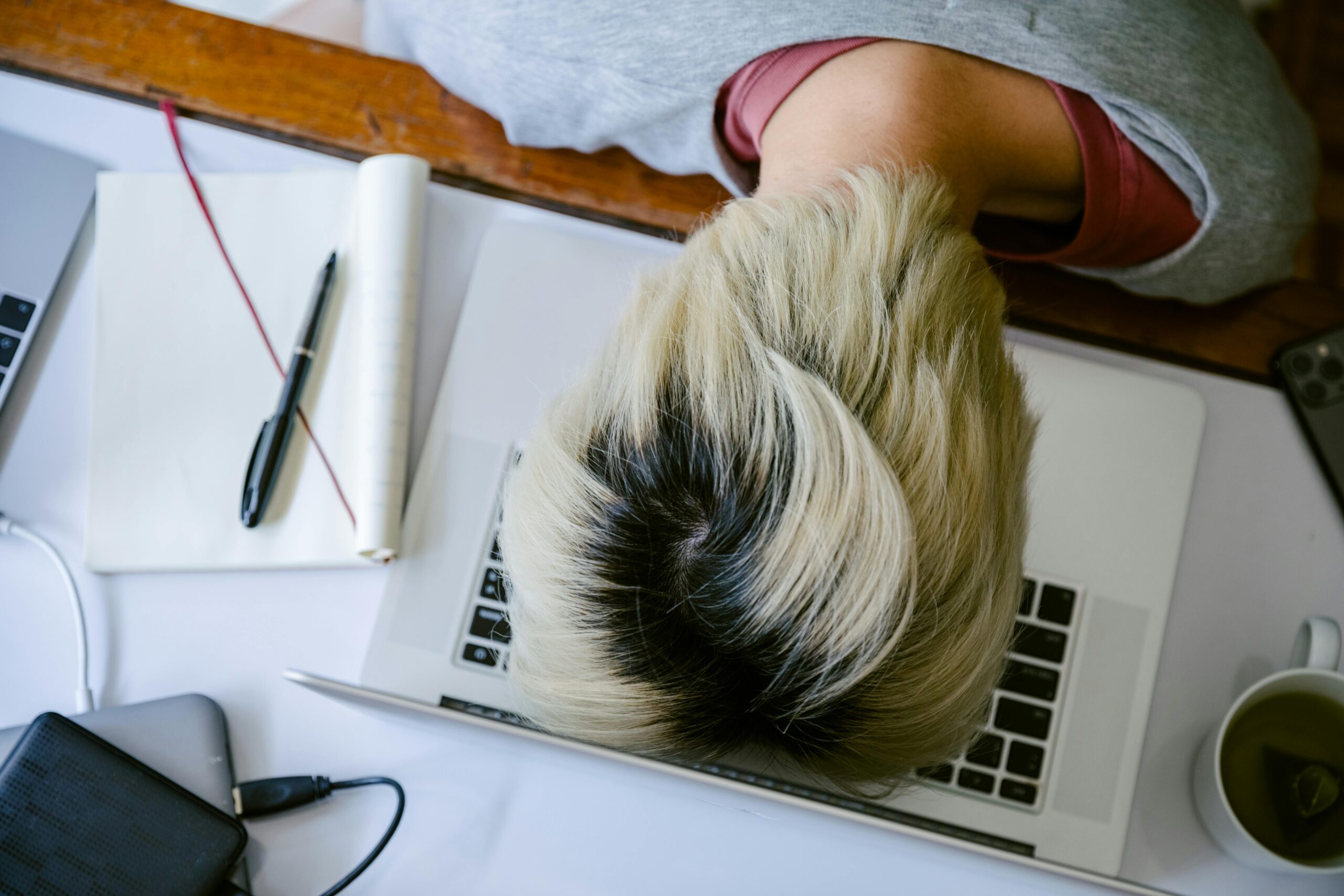 woman asleep on keyboard for Nervous System Dysregulation: Signs and Impact on Mental Health post