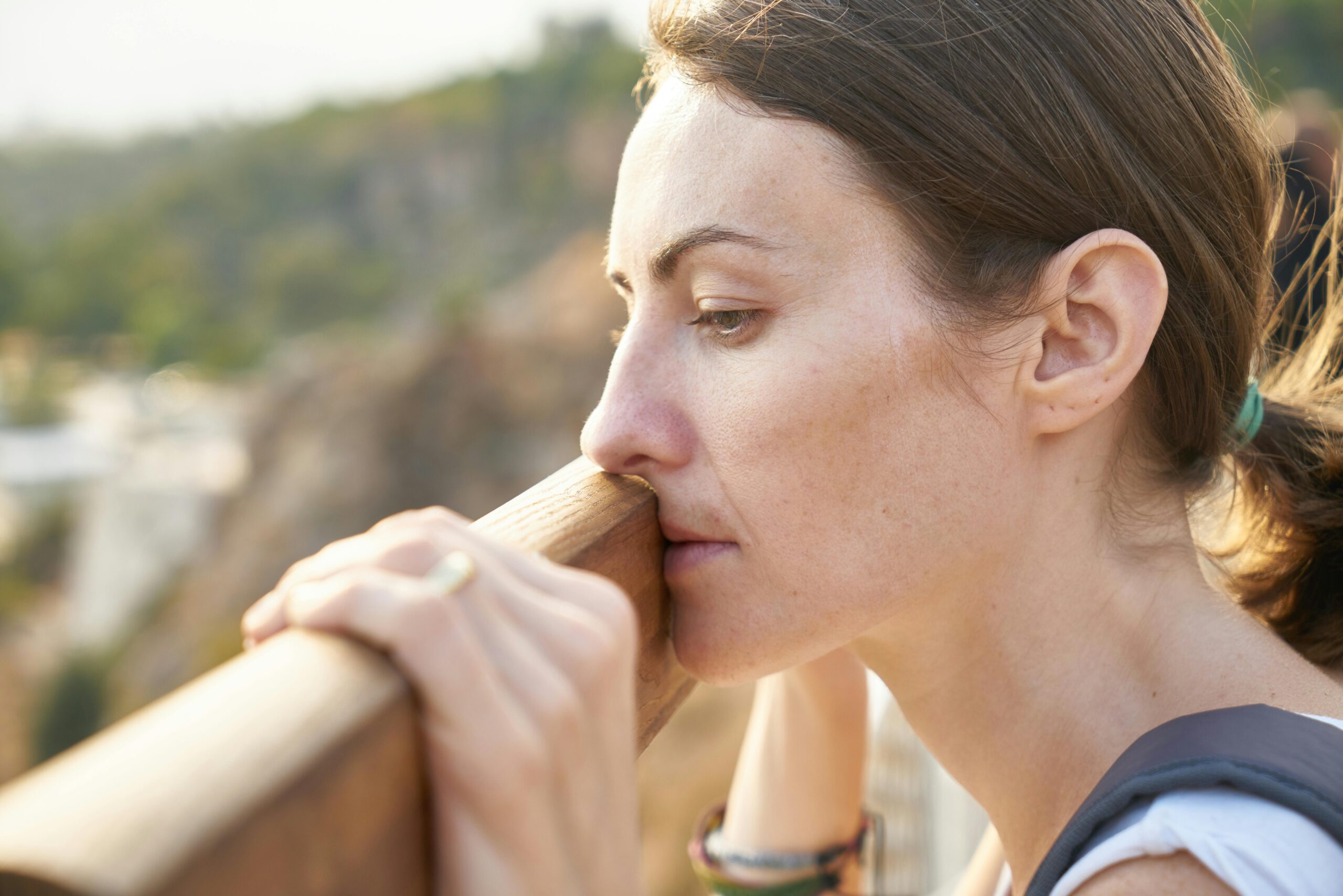 woman leaning on a post looking depressed for the What Is the SLC6A4 Gene post