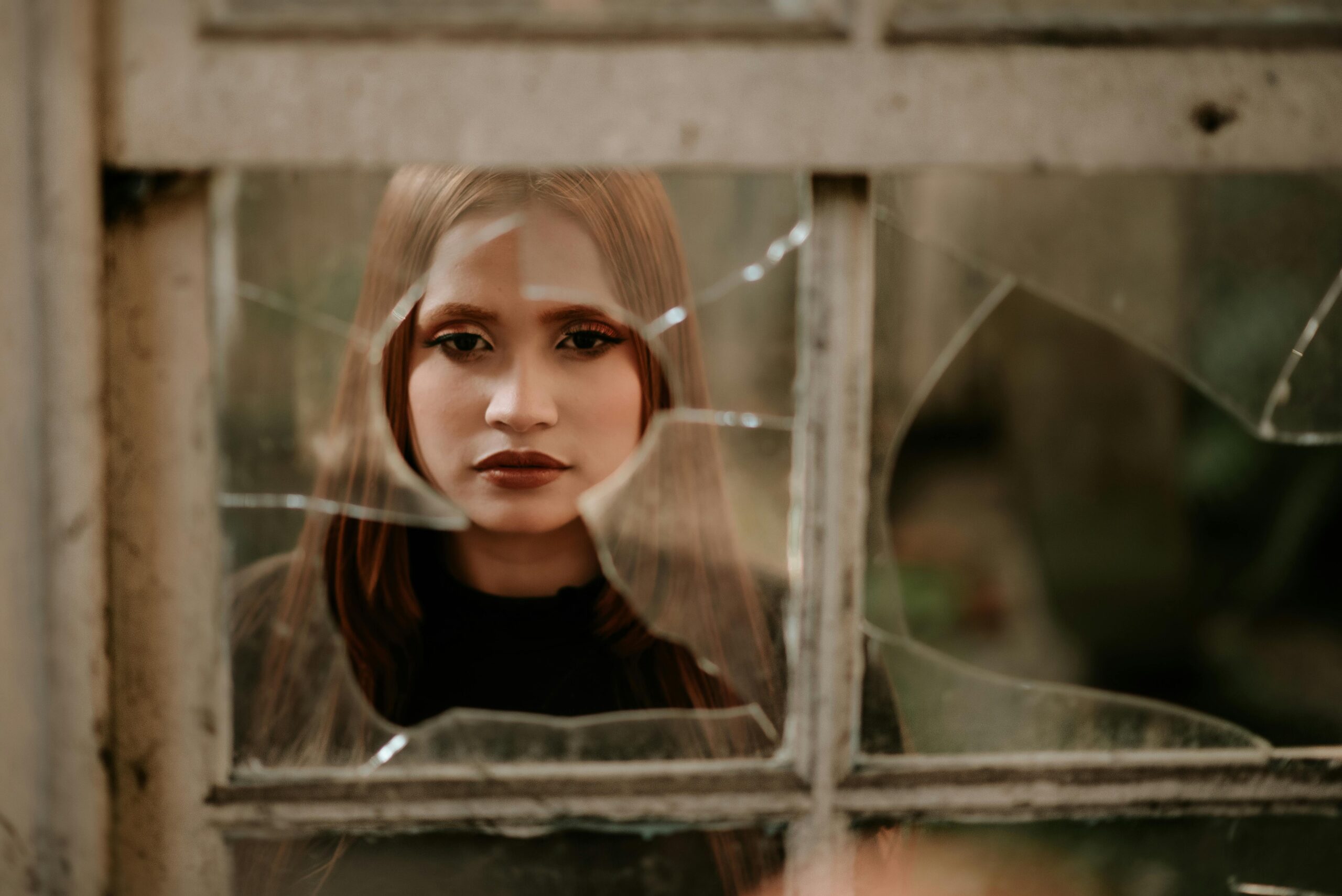 woman looking through broken glass for Gene Mutations Linked to ADHD & How to Test for Them post