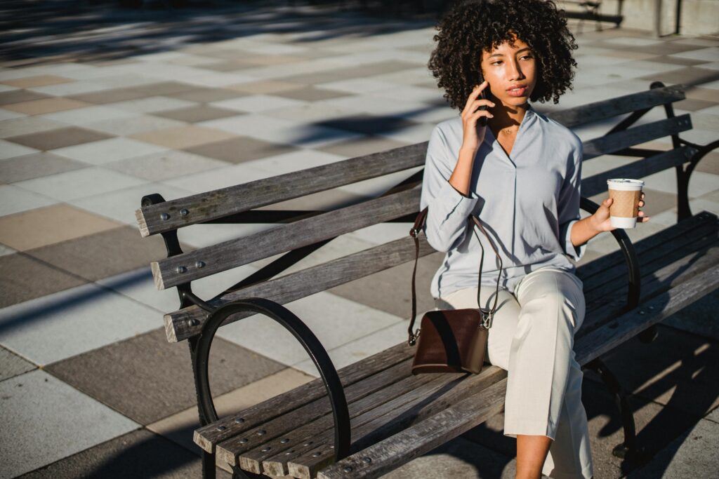 Woman sitting on a park bench talking on the phone